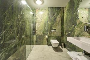 a bathroom with a shower and a toilet and a sink at Hotel AP in Kalisz
