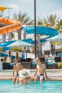 three young boys sitting in a swimming pool at Anaheim Resort Suites in Anaheim