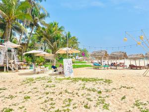 a beach with tables and chairs and umbrellas at Villa Jesmin Home - Sea View in Habaraduwa Central