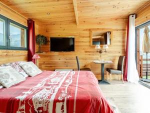 a bedroom with a bed and a television and a table at Gîtes Le Cerf de Belledonne in Sainte-Agnès