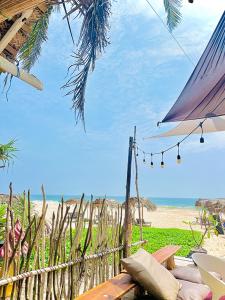 a view of a beach with a bench and an umbrella at Villa Jesmin Home - Sea View in Habaraduwa Central