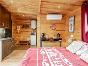 a bedroom with a bed and a kitchen with wooden walls at Gîtes Le Cerf de Belledonne in Sainte-Agnès