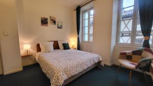 ein Schlafzimmer mit einem Bett und einem Fenster in der Unterkunft Le Sed' in Nérac