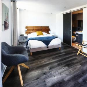 a bedroom with a bed and a chair at Hotel Napoleon in Île dʼAix