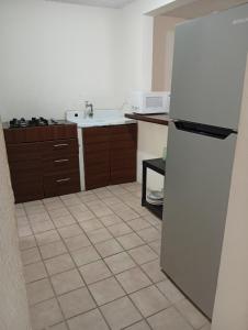 a kitchen with a refrigerator and a tile floor at Two-bedroom condo Ground floor in Santa Cruz Huatulco +3 photos