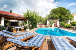 a swimming pool with chaise lounges and a swimming poolvisorvisorvisor at Villa Beganović in Krk