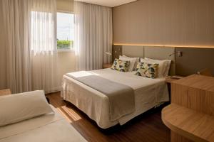a hotel room with a bed and a window at Rio Hotel by Bourbon Campinas in Campinas