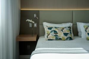 a bedroom with a bed with a vase of flowers on it at Rio Hotel by Bourbon Campinas in Campinas