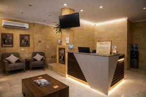a lobby with a reception desk and a tv on the wall at Pyramids Holiday Escape in Cairo