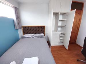 a small bedroom with a bed and a closet at Marito in Juliaca