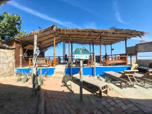 a pavilion with a picnic table and a bench next to a pool at Mancora Beach House in Máncora