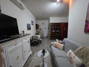 a living room with a couch and a flat screen tv at Casa Nicole in Assemini +2 photos