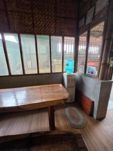 a room with a wooden table and some windows at Aloha Aina Dive Resort in Mabini