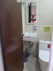 a bathroom with a sink and a toilet and a mirror at Aloha Aina Dive Resort in Mabini