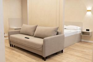 a couch sitting in a room with a bed at Мегаполис in Astana
