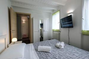 a bedroom with a bed with two white towels on it at Lake-Hot Springs-Gardaland, Private Parking at Dolce Duplex Lazise in Lazise