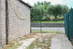 a fence next to a building with a giraffe at Lake-Hot Springs-Gardaland, Private Parking at Dolce Duplex Lazise in Lazise