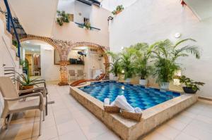 a pool in a living room with plants at Casa Payis Hotel in Cartagena de Indias