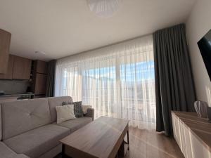 a living room with a couch and a table at Sekvoja view apartment in Nová Baňa