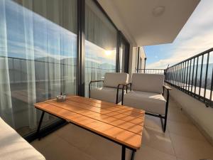 a balcony with a wooden table and two chairs at Sekvoja view apartment in Nová Baňa