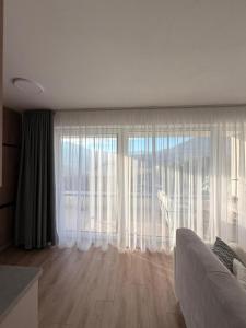 a living room with a couch and a large window at Sekvoja view apartment in Nová Baňa