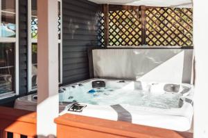 a jacuzzi tub on the porch of a house at Sunset Cottage Hocking Hills in Rockbridge +98 photos