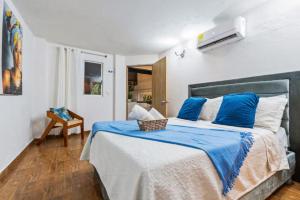 a bedroom with a large bed with blue pillows at Casa Payis Hotel in Cartagena de Indias +42 photos