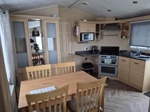a kitchen with a wooden table and a table and chairs at Ocean Front Lodge in Hartlepool