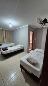 a bedroom with two beds and a window at Hotel Universo in Goiânia
