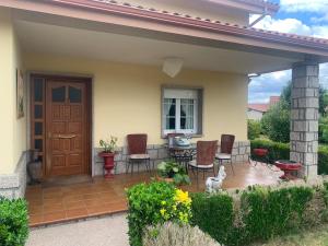 a porch of a house with chairs and a door at Lar do Pero - Ribeira Sacra in Tioira