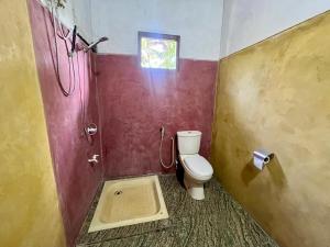 a small bathroom with a toilet and a window at Farmhouse Homestay in Negombo