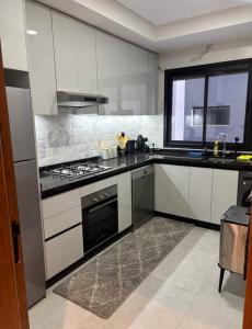 a kitchen with white cabinets and a stove top oven at You apparemment in Tangier