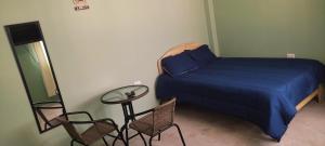 a bedroom with a bed and a table and chairs at Casa de Juanita in Cajamarca