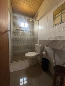a bathroom with a toilet and a glass shower at Casa Buddha in Imbituba +35 photos