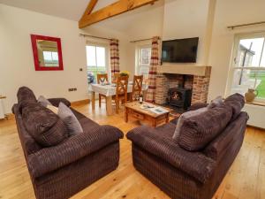 a living room with two couches and a fireplace at West Gate in Embleton