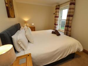 a bedroom with a large white bed with a window at West Gate in Embleton +31 photos