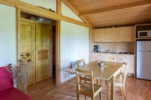 a kitchen and dining room with a wooden table at Camping nature 3 étoiles - au coeur des montagnes du Jura in Levier