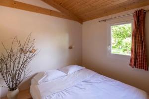 a bedroom with a bed and a window at Camping nature 3 étoiles - au coeur des montagnes du Jura in Levier