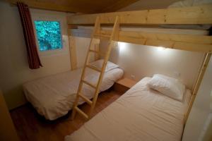 a bedroom with two bunk beds and a ladder at Camping nature 3 étoiles - au coeur des montagnes du Jura in Levier