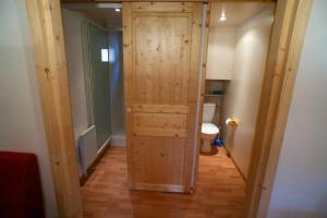 a hallway with a wooden door leading to a toilet at Camping nature 3 étoiles - au coeur des montagnes du Jura in Levier +60 photos