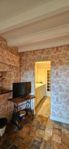 a room with a table and a kitchen with wallpaper at Moulin Notre Dame in Saint-Genès-de-Castillon