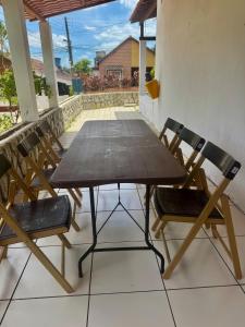 a wooden table and two chairs on a porch at Casa com Piscina em Gravatá Carnaval in Gravatá