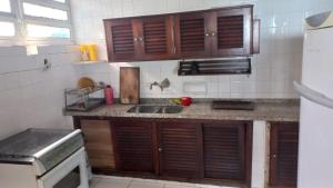 a kitchen with wooden cabinets and a counter top at casa azul in Itanhaém