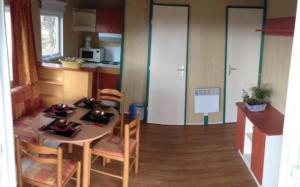 a kitchen and dining room with a table and chairs at ZEcamping 4 étoiles animaux acceptés tennis pataugeoire in Tamniès
