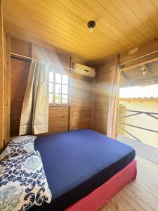 a bedroom with a bed in a room with a window at Casa Buddha in Imbituba