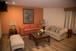 a living room with two couches and a coffee table at Hotel La Loma Tepic in Tepic