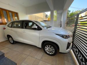 a small white car parked in a garage at Santhosh Villa in Thanjāvūr