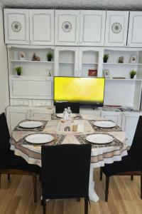 a dining room table with chairs and a yellow wall at Friendly two-room apartment in Sigulda