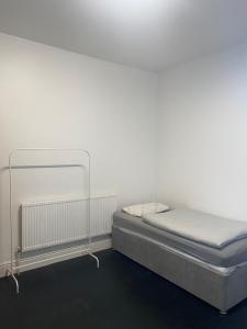 a bed in a room with a white wall at Contractor House with parking in Worksop