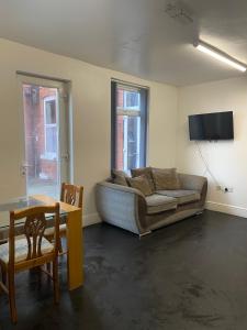 a living room with a couch and a table at Contractor House with parking in Worksop